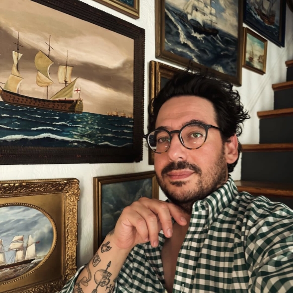 Memo Faraj poses in front of a maximalist gallery wall vignette | BRG