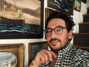 Memo Faraj poses in front of a maximalist gallery wall vignette | BRG